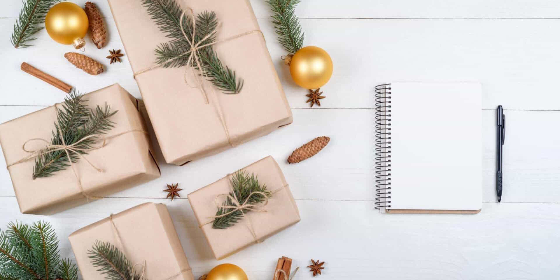 Ideias de presentes de Natal com cadernos, papelaria e um presente embrulhado